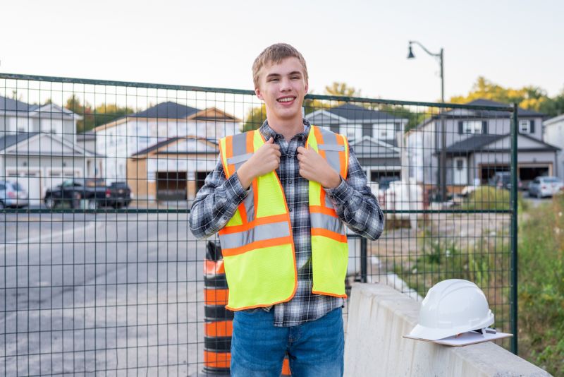 Young construction worker wearing safety gear on job site
