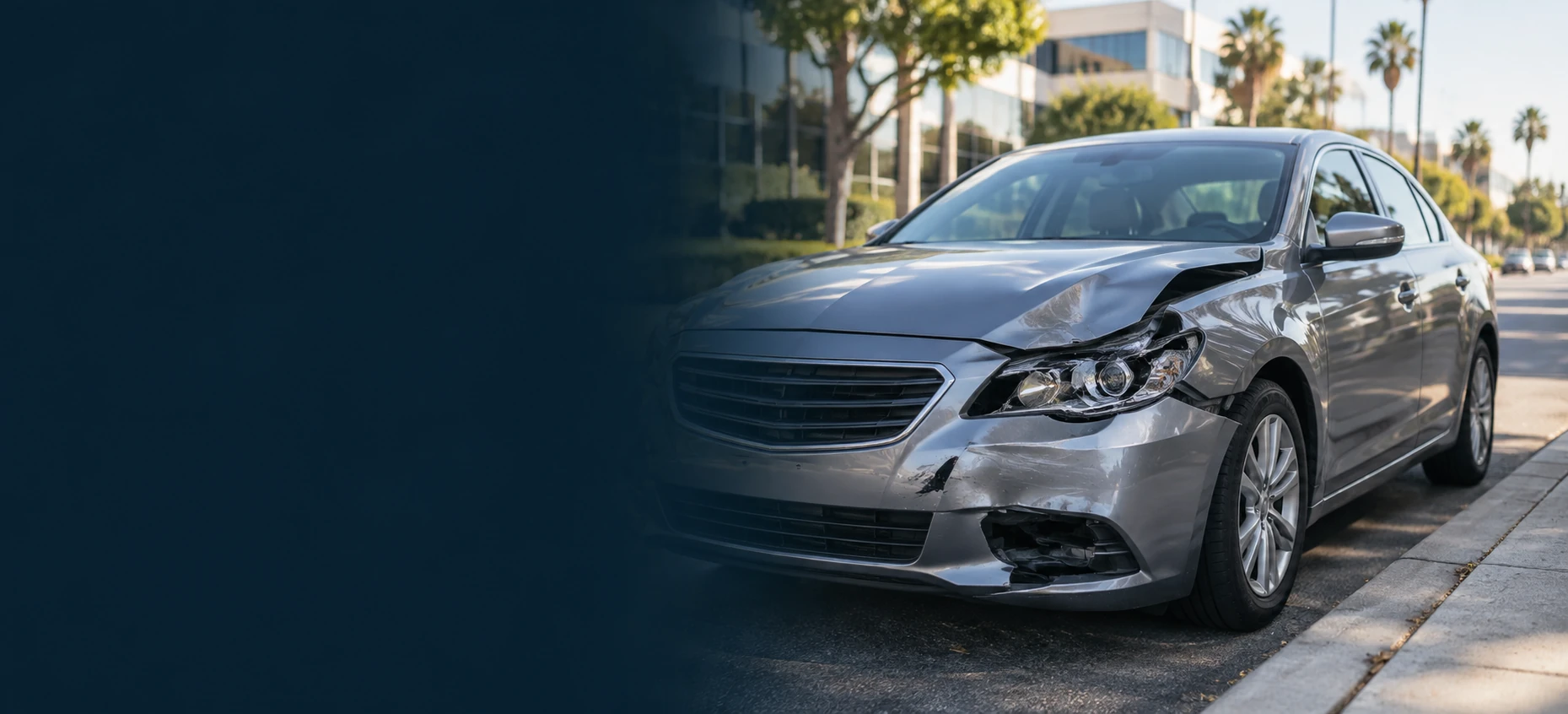 Silver passenger car with collision damage parked beside a California street